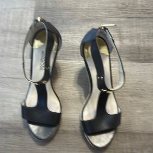 Black pair of Michael Kors wedge. In a size 10